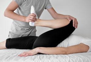 a lady going through physiotherapy for her leg in a clinic